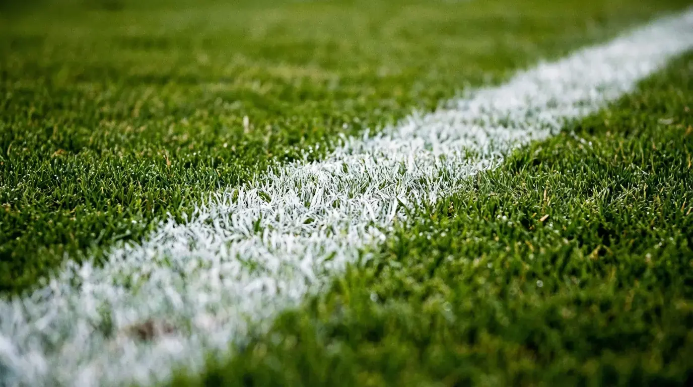 Jalkapallostadionin vastaleikattu nurmi ja valkoiset rajaviivat lähikuvassa