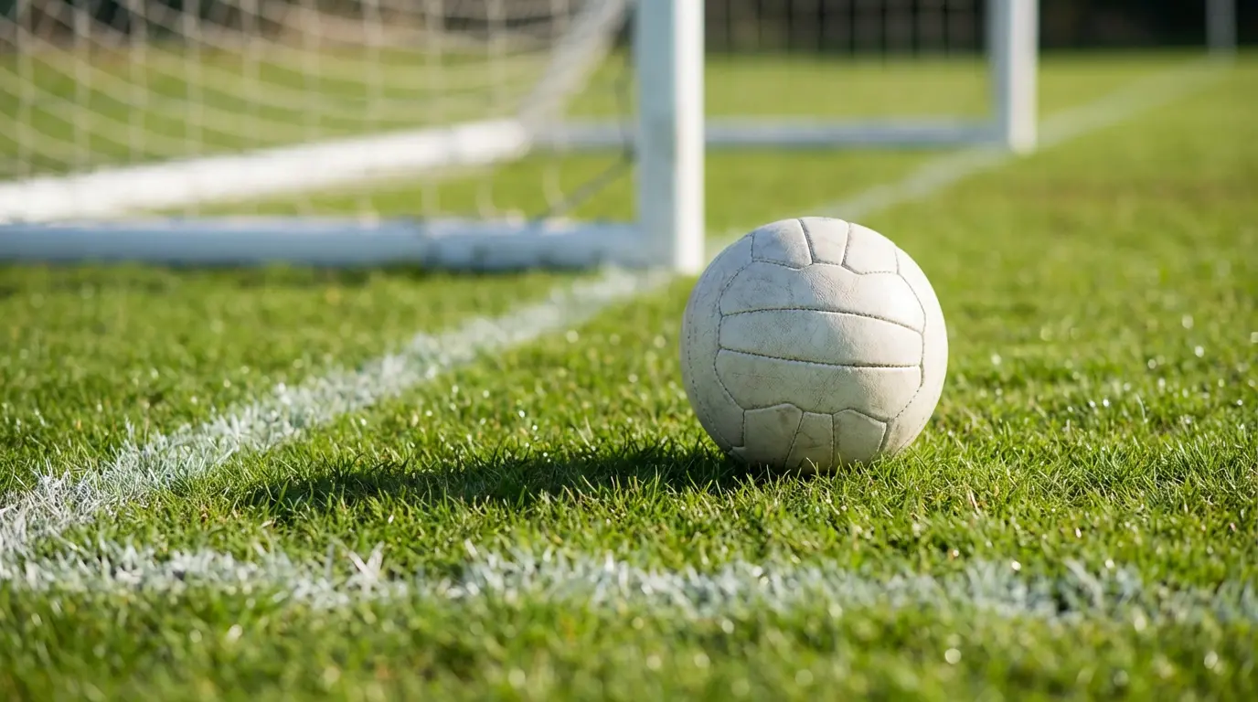 Jalkapallo vihreällä nurmikentällä maalitolpan edessä auringonvalossa